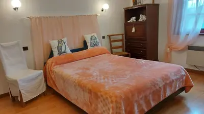 a bedroom with a large bed and a chair at Villa Aimé in Caunes-Minervois