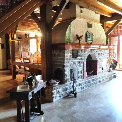 a stone fireplace in a room with a table at Villa Aimé in Caunes-Minervois