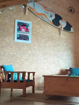 a surfboard hanging on a wall next to two benches at VENEZ SEJOURNER A GRUISSAN ....PLAGE DES CHALETS in Gruissan