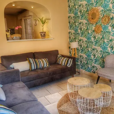 a living room with a couch and two chairs and a mirror at La maison bleue in Lautrec