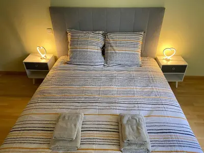 a large bed with two nightstands and two lamps at La maison bleue in Lautrec
