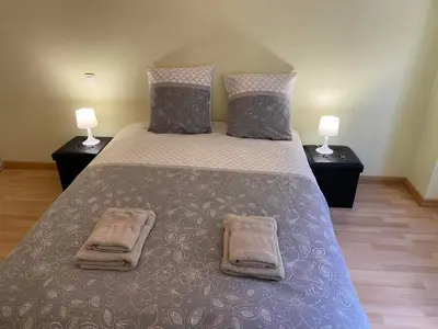 a bedroom with a large bed with two lamps at La maison bleue in Lautrec