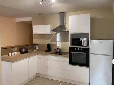 a kitchen with white cabinets and a white refrigerator at La maison bleue in Lautrec