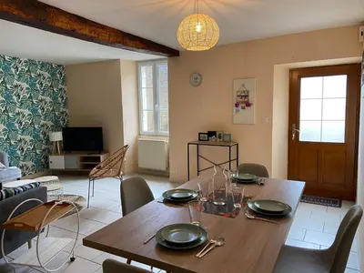 a dining room with a wooden table and chairs at La maison bleue in Lautrec