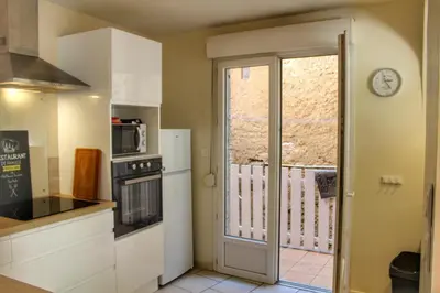 a kitchen with a door leading to a balcony at La maison bleue in Lautrec