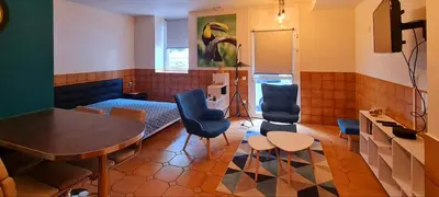 a living room with a table and chairs at Mazamet : Résidence du Musée centre ville. in Mazamet