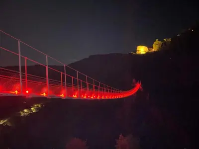 a bridge lit up at night with red lights at Mazamet : Résidence du Musée centre ville. in Mazamet