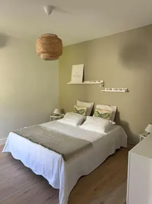 a bedroom with a large white bed in a room at Le Marceau - Maison climatisée avec jardin in Carcassonne