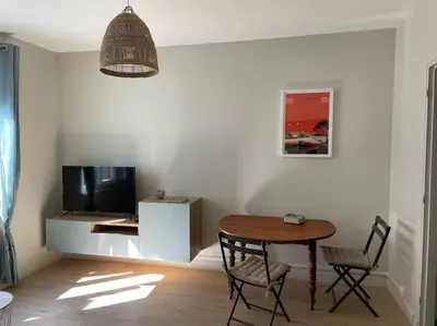 a living room with a table and a television at Le Marceau - Maison climatisée avec jardin in Carcassonne