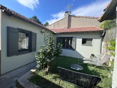 a small yard with a bench in front of a house at Le Marceau - Maison climatisée avec jardin in Carcassonne