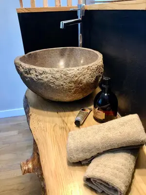 a bathroom with a stone sink on a wooden table at Panorama Suite & Spa in Carcassonne