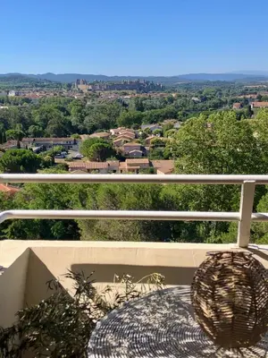 a balcony with a table and a view of a city at Panorama Suite & Spa in Carcassonne