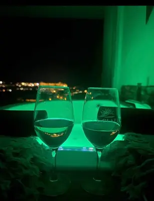 two glasses of wine sitting on a table at night at Panorama Suite & Spa in Carcassonne