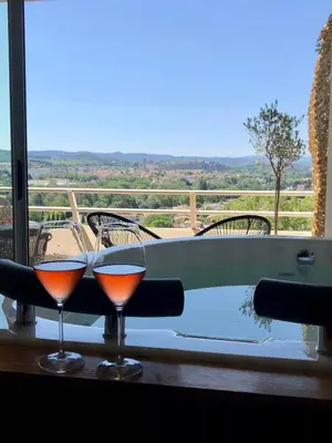 two glasses of wine sitting on a table next to a bath tub at Panorama Suite & Spa in Carcassonne
