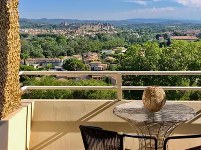 a table and chairs on a balcony with a view at Panorama Suite & Spa in Carcassonne