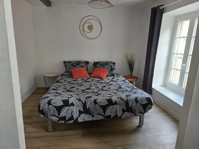 a bedroom with a bed with two red pillows at Superbe appartement au cœur du centre ville in Carcassonne