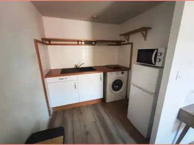 a small kitchen with a refrigerator and a microwave at Superbe appartement au cœur du centre ville in Carcassonne