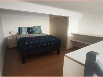 a bedroom with a bed with blue pillows on it at Superbe appartement au cœur du centre ville in Carcassonne