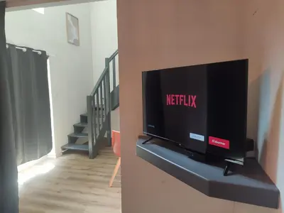 a flat screen tv sitting on a shelf in a living room at Superbe appartement au cœur du centre ville in Carcassonne