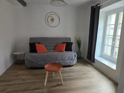 a living room with a couch and a stool at Superbe appartement au cœur du centre ville in Carcassonne