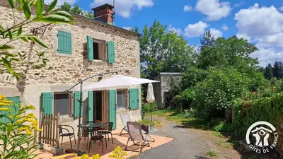 a house with a table and chairs and an umbrella at Guyor in Le Bez