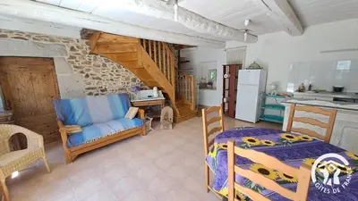 a kitchen and a living room with a bed and a table at Guyor in Le Bez