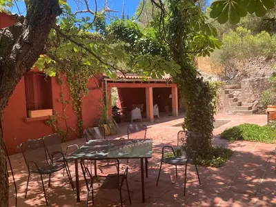 a patio with a table and chairs under a tree at Maison au coeur d'un vignoble in Cases-de-Pène