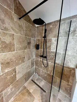 a shower with a glass door in a bathroom at Le Donjon de Lily - Cœur de La Cité Médiévale in Carcassonne