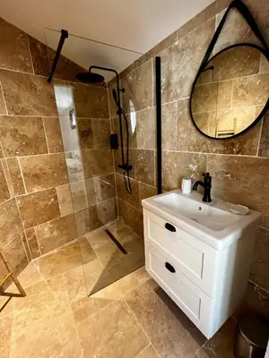 a bathroom with a sink and a shower with a mirror at Le Donjon de Lily - Cœur de La Cité Médiévale in Carcassonne