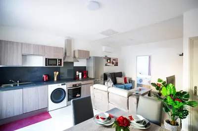 a kitchen and living room with a table and chairs at Superbe appartement à 2 pas des Halles, Climatisé, terrasse, garage in Narbonne