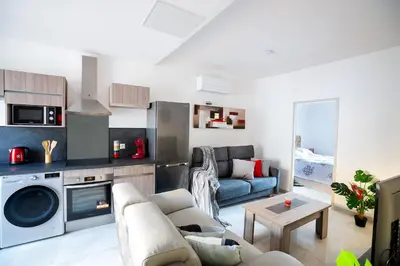 a living room with a couch and a table at Superbe appartement à 2 pas des Halles, Climatisé, terrasse, garage in Narbonne