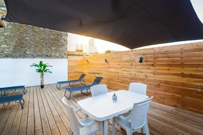 a white table and chairs on a wooden deck at Superbe appartement à 2 pas des Halles, Climatisé, terrasse, garage in Narbonne