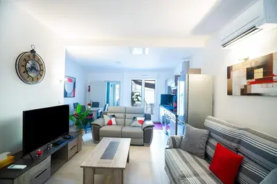 a living room with a couch and a tv at Superbe appartement à 2 pas des Halles, Climatisé, terrasse, garage in Narbonne