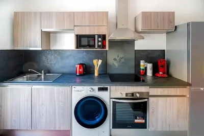 a kitchen with a washing machine and a sink at Superbe appartement à 2 pas des Halles, Climatisé, terrasse, garage in Narbonne