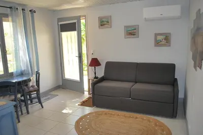 a living room with a couch and a table at Au Canalet - Le Somail in Le Somail