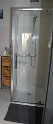 a shower with a glass door in a bathroom at Au Canalet - Le Somail in Le Somail