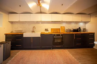 a kitchen with black cabinets and a sink at Beautiful converted one bedroom apartment in Carcassonne