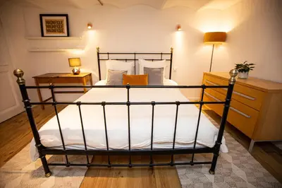 a bedroom with a black bed with white sheets at Beautiful converted one bedroom apartment in Carcassonne