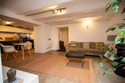 a living room with a couch and a table at Beautiful converted one bedroom apartment in Carcassonne