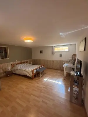 a bedroom with a bed and a desk in it at chez Angélique in Marcorignan