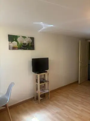 a living room with a tv and a chair at chez Angélique in Marcorignan