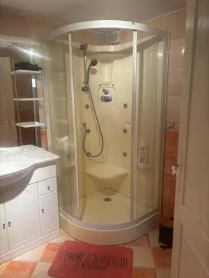 a shower with a glass door in a bathroom at chez Angélique in Marcorignan