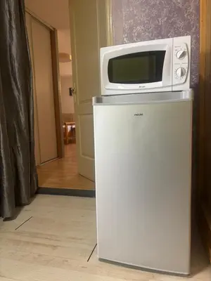 a microwave sitting on top of a refrigerator at chez Angélique in Marcorignan