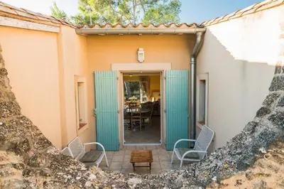 a doorway to a house with chairs and a table at Le gite de la closerie des iris in Castelnau-dʼAude