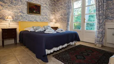 a bedroom with a bed with blue wallpaper at Le gite de la closerie des iris in Castelnau-dʼAude