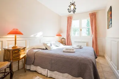 a bedroom with a bed and a table and a window at Le gite de la closerie des iris in Castelnau-dʼAude