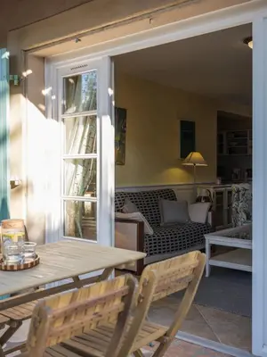 a porch with a table and chairs and a couch at Le gite de la closerie des iris in Castelnau-dʼAude