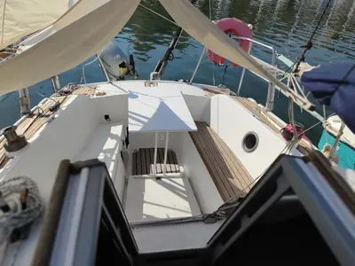 a white boat in the water with a dock at St Helene in Gruissan