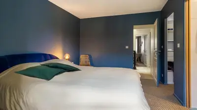 a bedroom with a large white bed with green pillows at Belle et grande maison de village au bord de l'eau in Peyriac-de-Mer