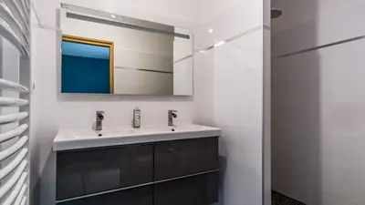 a bathroom with a sink and a mirror at Belle et grande maison de village au bord de l'eau in Peyriac-de-Mer
